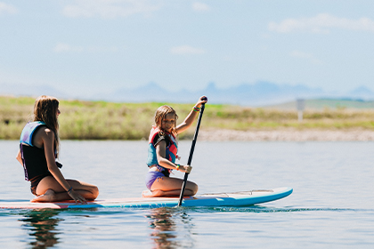 kids paddle-boarding on the Harmony Lake